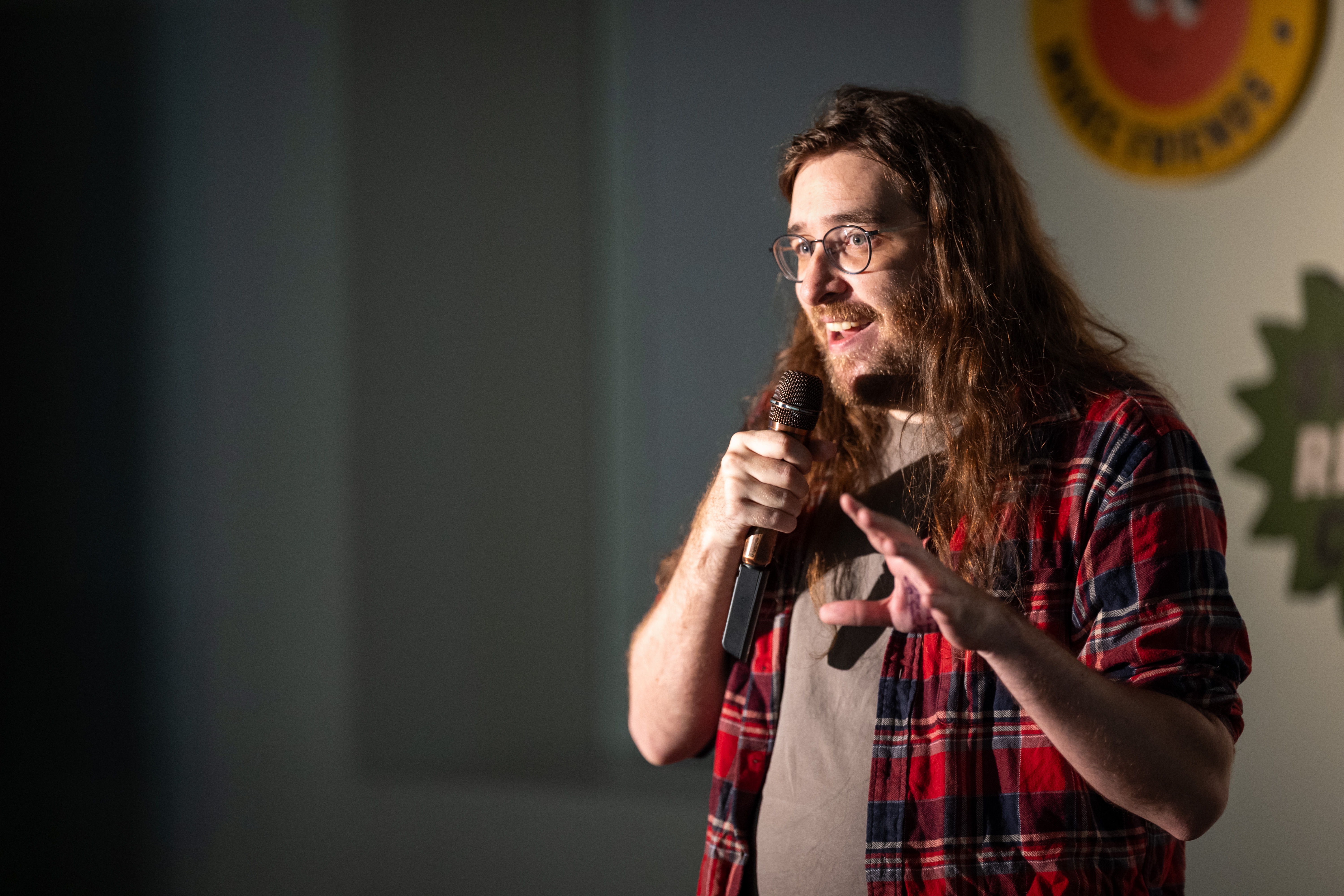Close up photo of Craig holding a microphone on a stand up stage