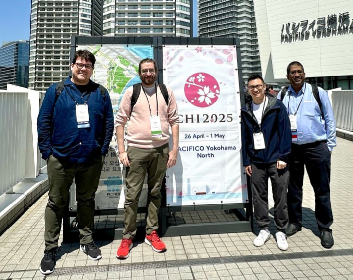 Photo of Craig and colleagues standing in front of the CHI 2025 conference sign in Yokohama, Japan